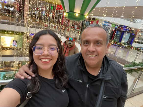A father and daughter are standing in a shopping mall.