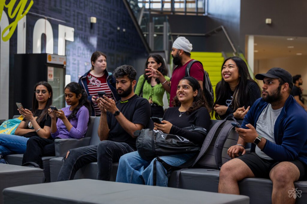 Students sitting the IGNITE student centre playing games on their phone.