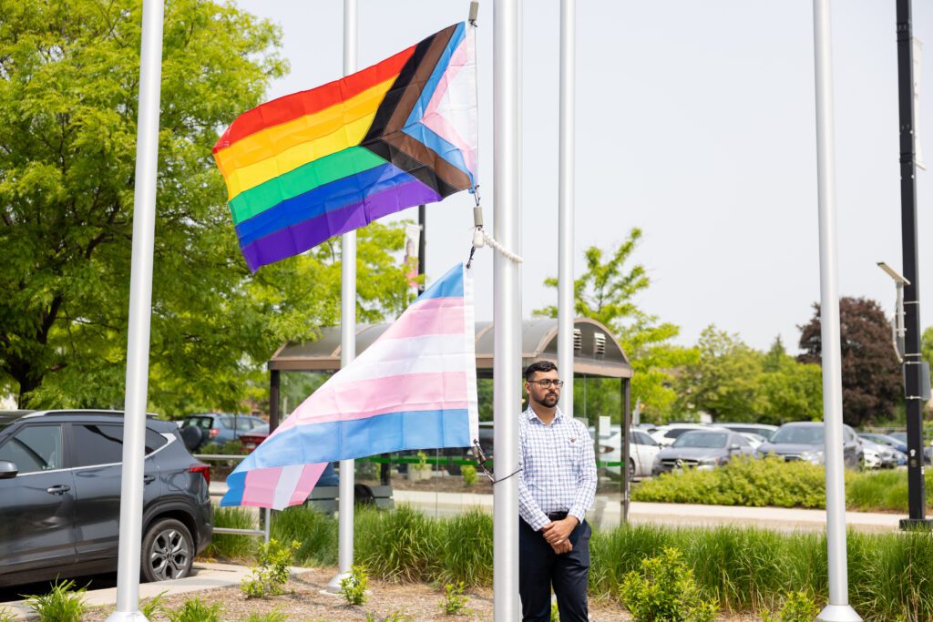 Pride flags are displayed on a flagpole.