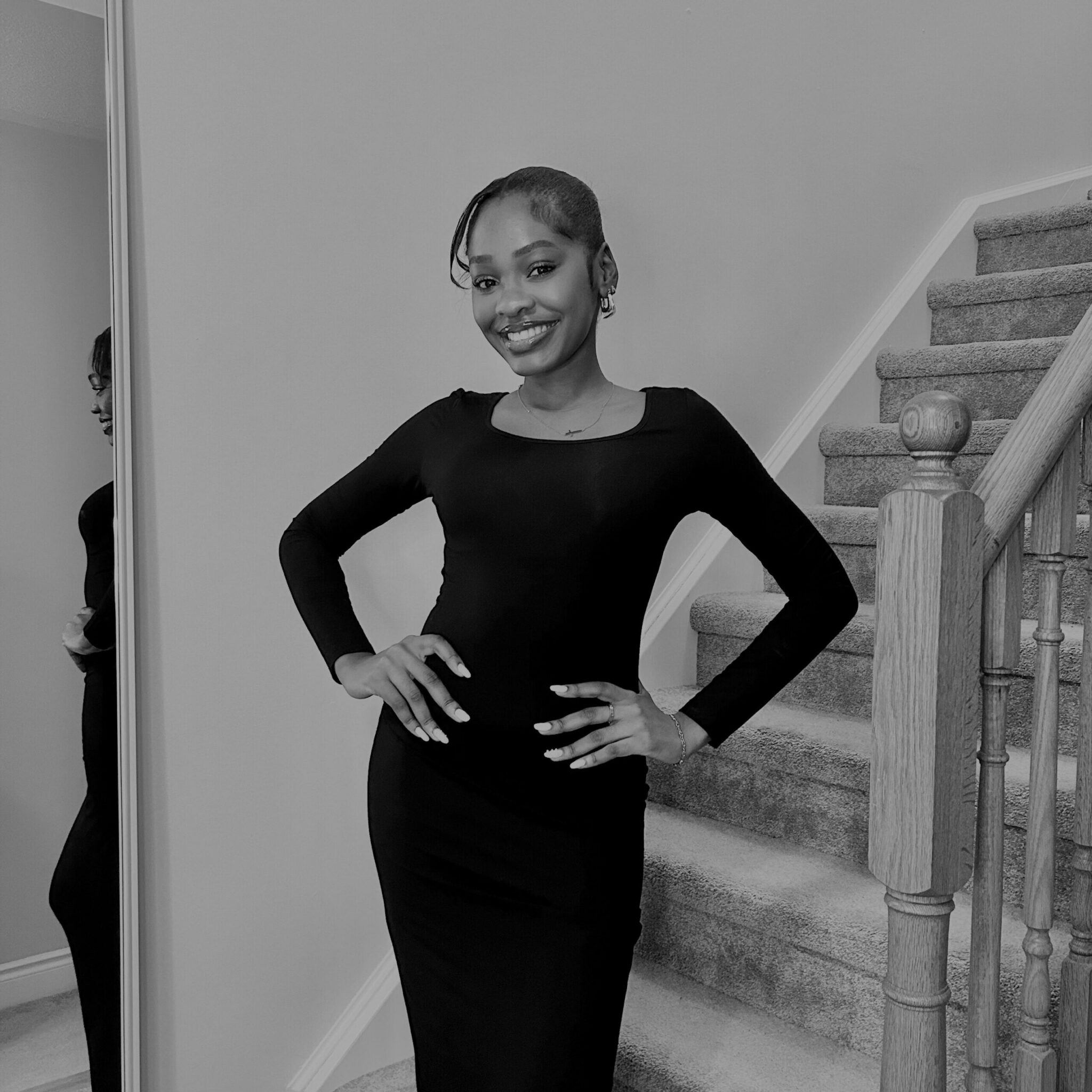 Black and white image of Dezerae Francis near staircase