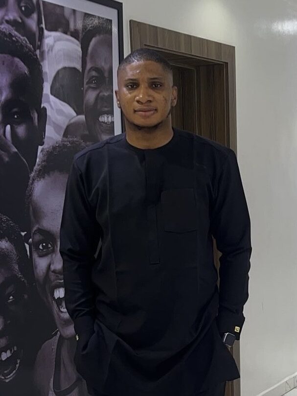 Recipient Emmanuel Inebode powerfully standing wearing a cultural outfit from Nigeria