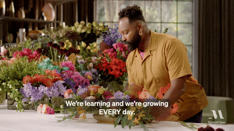A man saying, "We're learning and we're are growin EVERY day." whilearranging a flower decor.