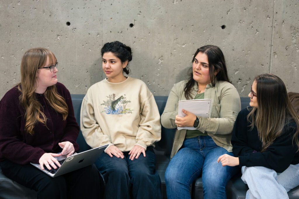 Emily Edwards and Selena Ferreira sitting and listening to students.