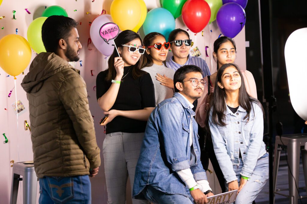A group of people wearing fun props are posing for a photo.