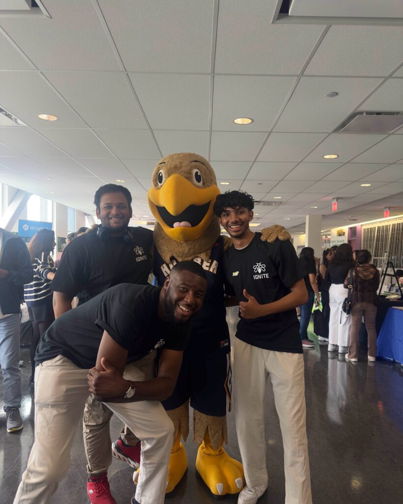 Three boys pose for a photo with Humber Polytechnic’s mascot - Howie the Hawk.