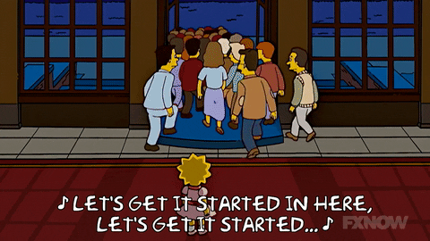 A scene from The Simpsons shows Lisa standing outside as a crowd of people enters a building, with subtitles displaying the lyrics "LET'S GET IT STARTED IN HERE, LET'S GET IT STARTED...".