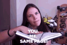 A woman saying, "You. Me. Same page!" as she glides her hand across an open book. 