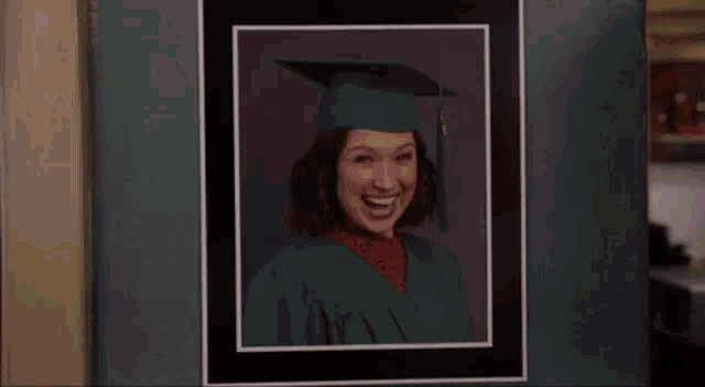 A close up picture of a grad photo with the girl graduating mimicking her smile on the photo.