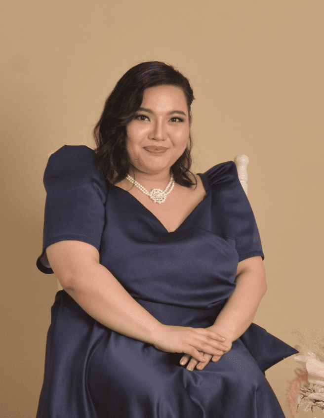 A picture of a sitting girl wearing blue gown.