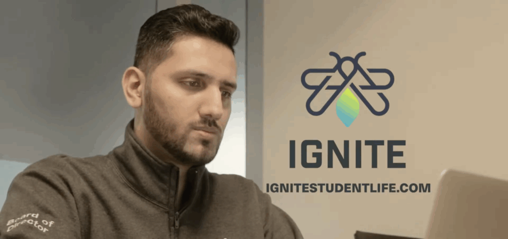 A man is looking at a screen with an IGNITE logo beside him.