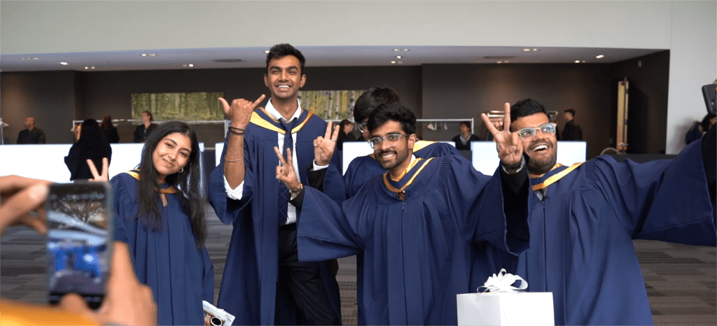 A group of people in graduation gowns are posing for a photo.