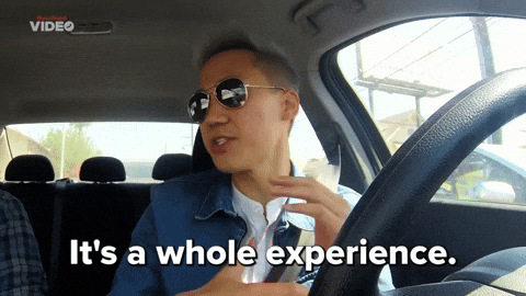 A man in a driver seat saying, "It's a whole experience." 