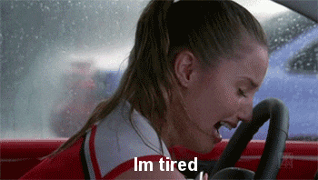 A woman crying in a car and saying "I'm tired."