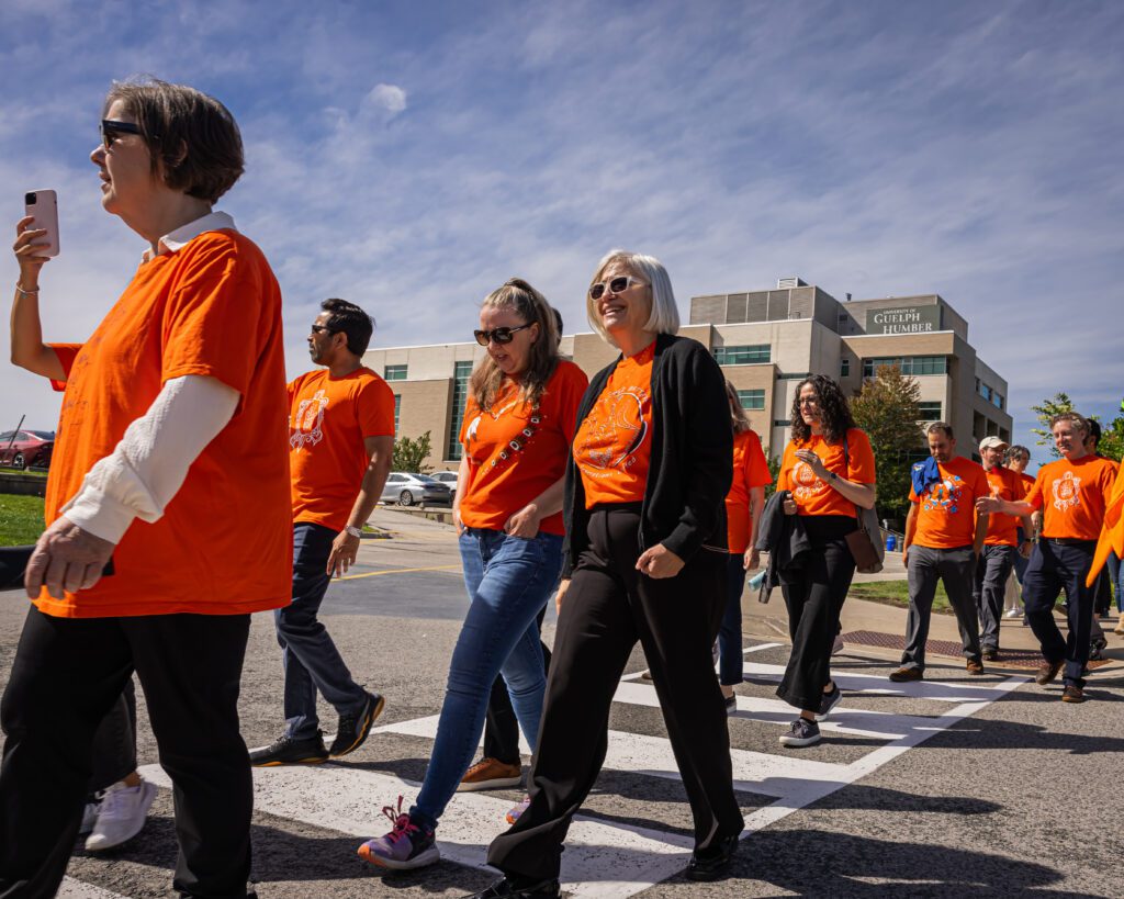 A group of people walking at the Walk for Reconciliation wearing orange.