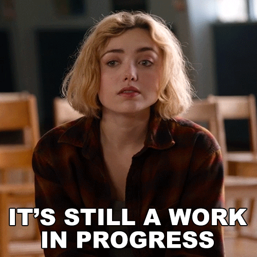 A woman saying "IT'S STILL A WORK IN PROGRESS."