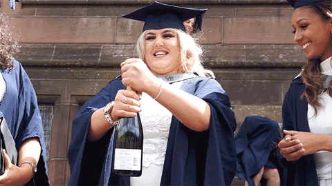 A girl opening a bottle of champagne.