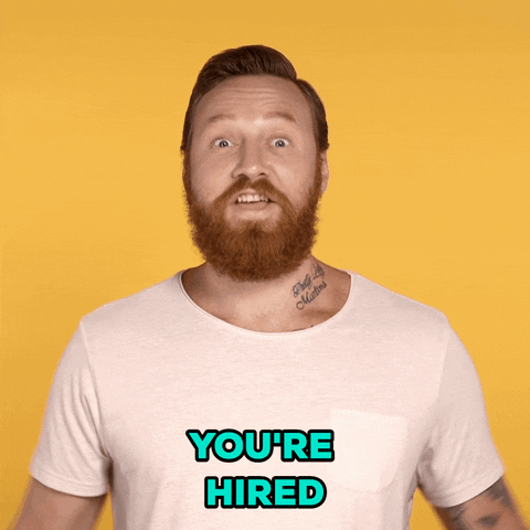 A man celebrating with a text saying "You're hired".