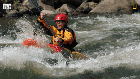 A man is river rafting in his kayak.
