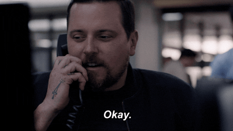A man is talking on the phone and saying the words, "Okay.
