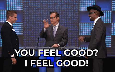 A man is asking another man, "YOU FEEL GOOD?" and the other man is replying, "I FEEL GOOD!" while another man is standing between them, raising a finger.