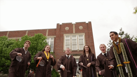 A group of people is throwing their graduation hats into the air.