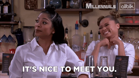 One woman is standing behind the counter and smiling, while another in the front is saying the words, “IT'S NICE TO MEET YOU.”