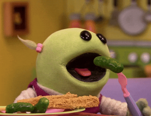 A puppet is eating green vegetables.