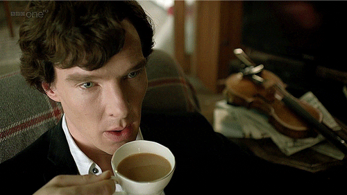 A man is holding a teacup filled with tea.
