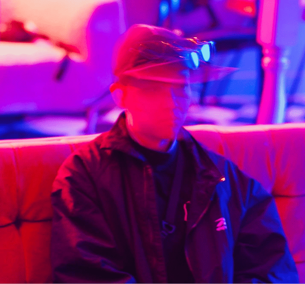 A man is sitting in a colourful room. 