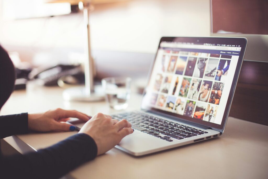A person looking through photos on a laptop.