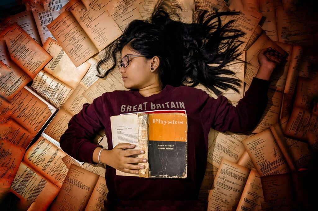Woman in red long sleeve holding a white and orange book