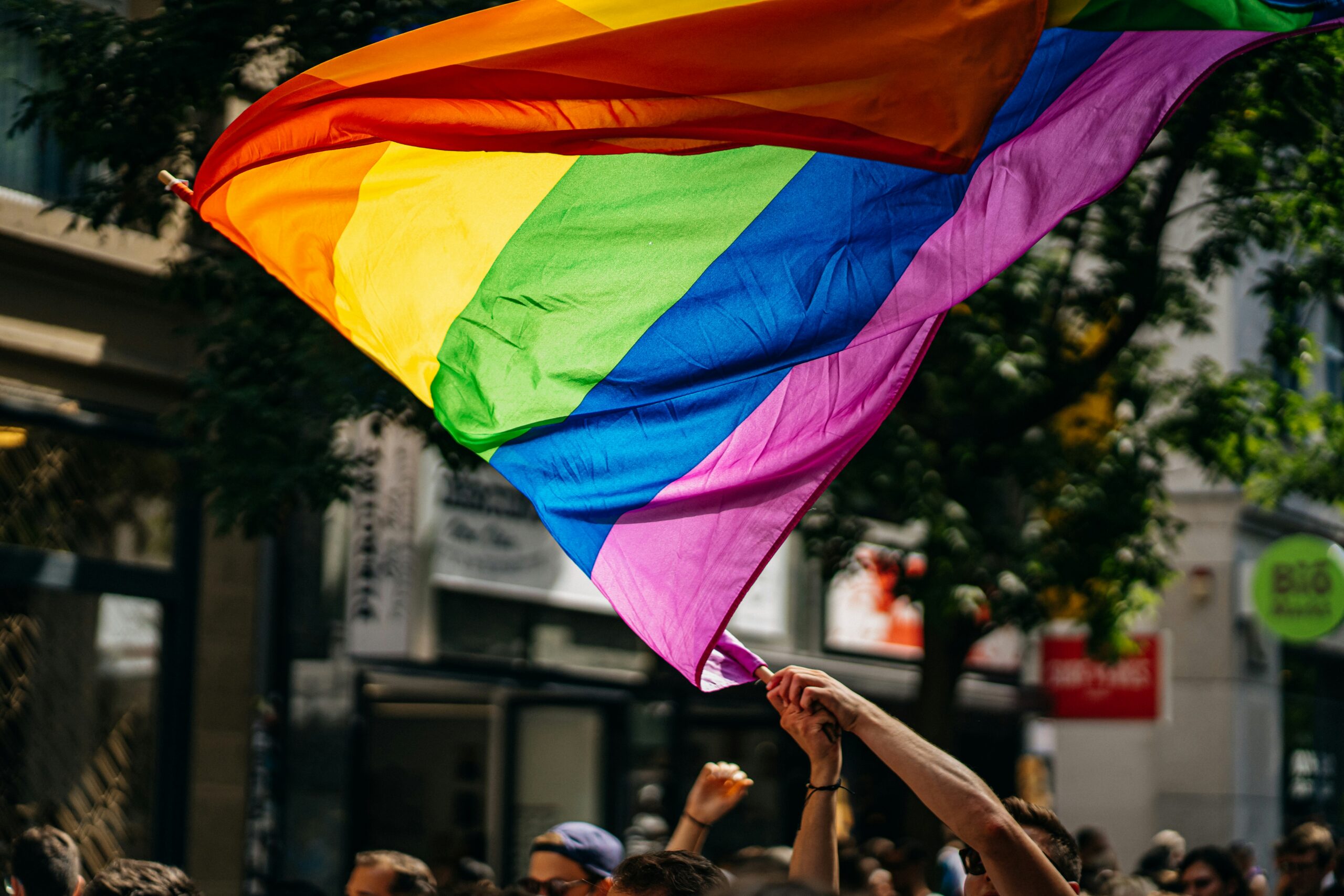 A pride flag being waved in the air