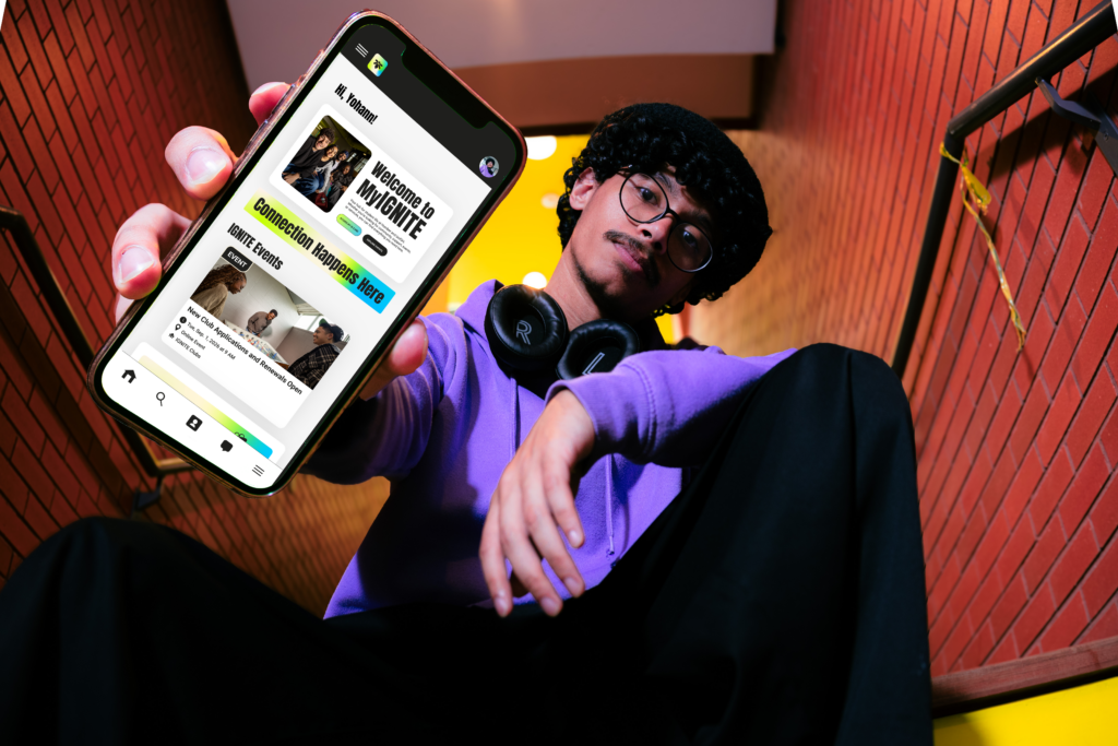A man holding a phone with the MyIGNITE app displayed on the screen 