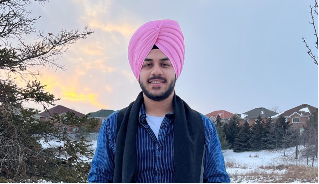 Board of Director Aksnoor Singh Kamboj smiling against a winter background.
