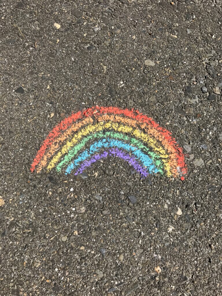 A rainbow drawn with chalk on the road