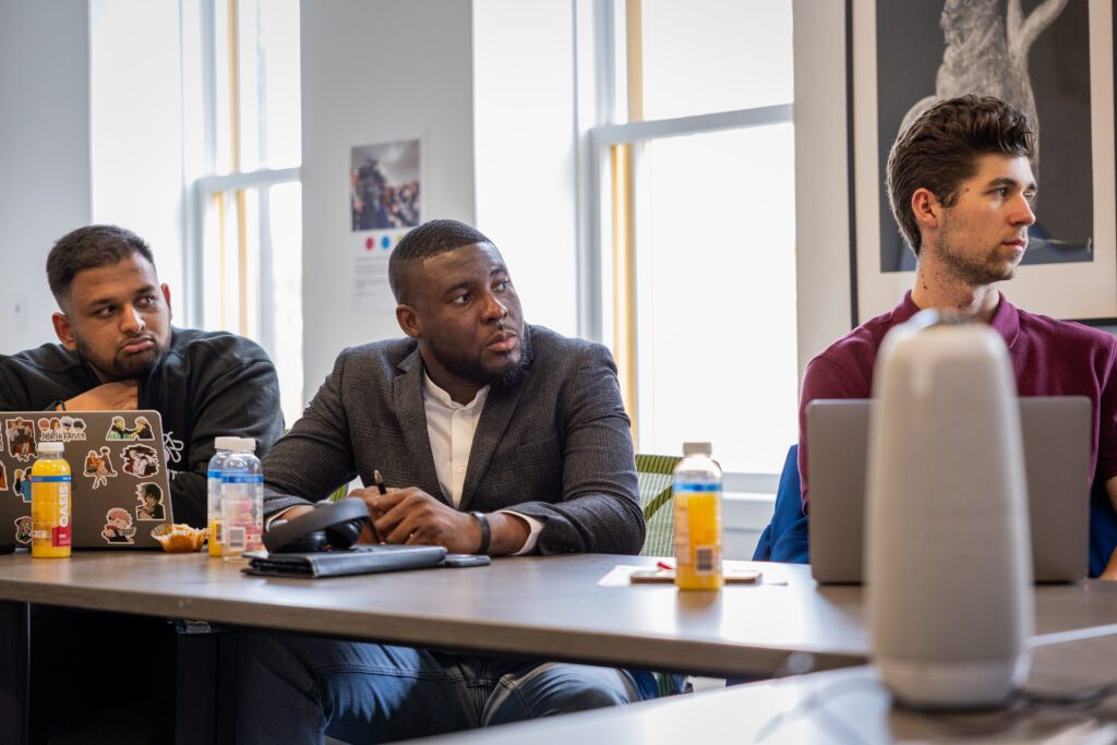 Onoriode Francis Osifo sitting at a table with two other IGNITE Board of Director members.