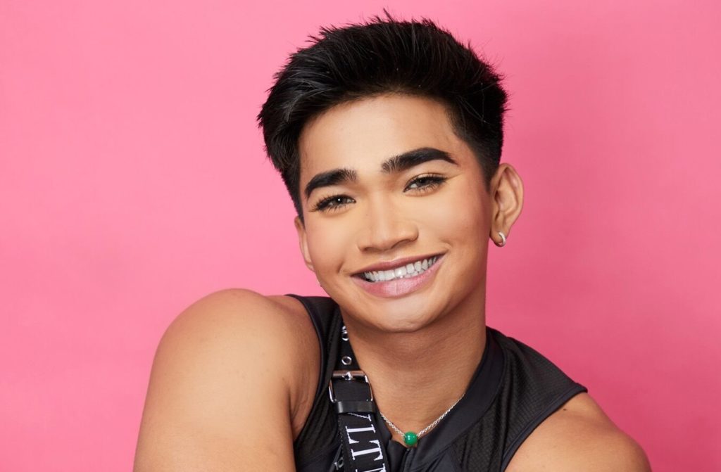 Bretman Rock smiling against pink background.