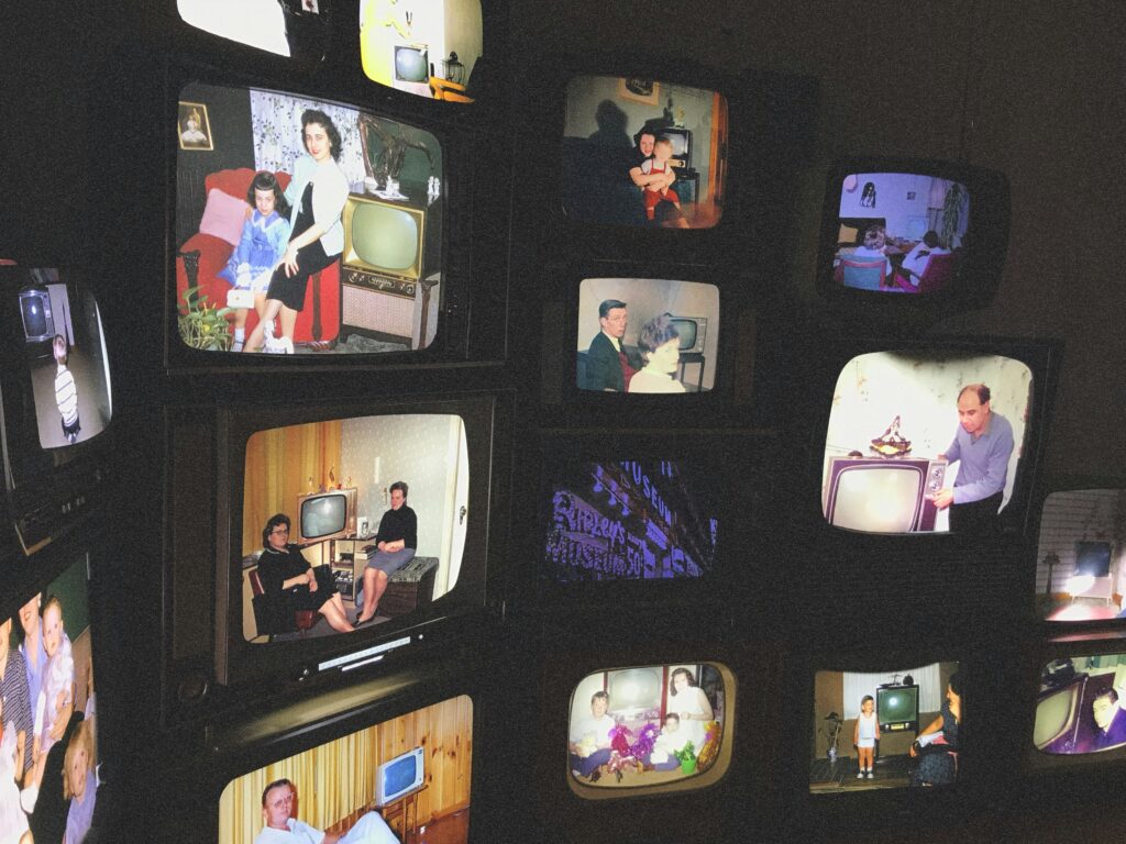 Mulitple vintage TV's diplaying old photos