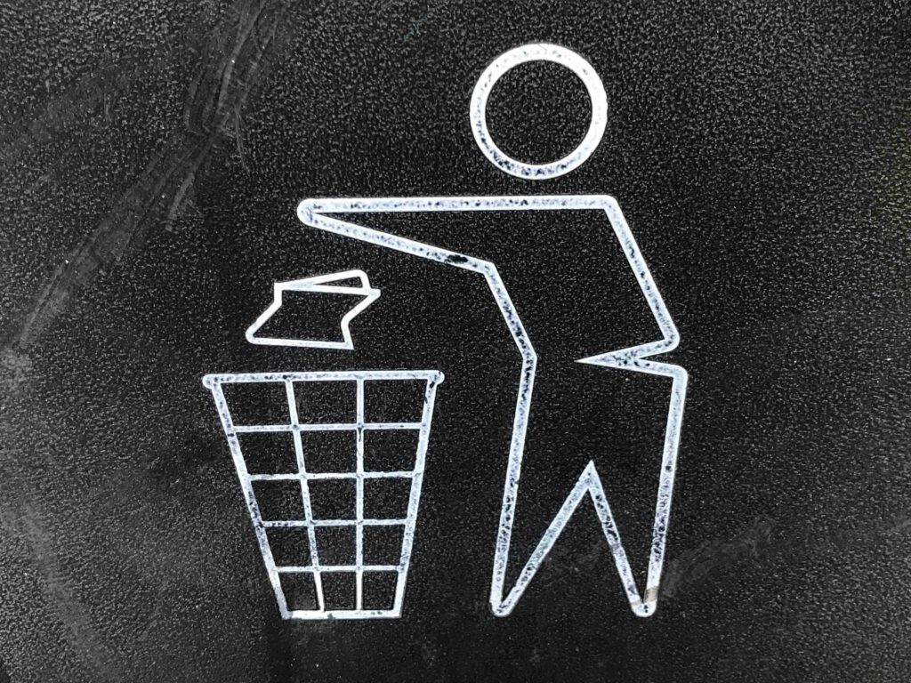 A drawing of a person throwing garbage into the trash can.