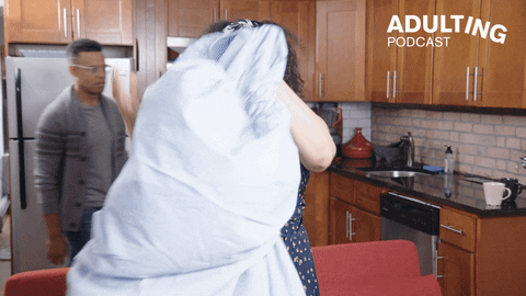 A woman crumples a fitted sheet.