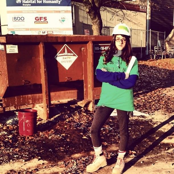 Teresa Silva-Byers is wearing a helmet and posing in front of a garbage bin.