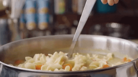 Pasta soup being ladled into a bowl.