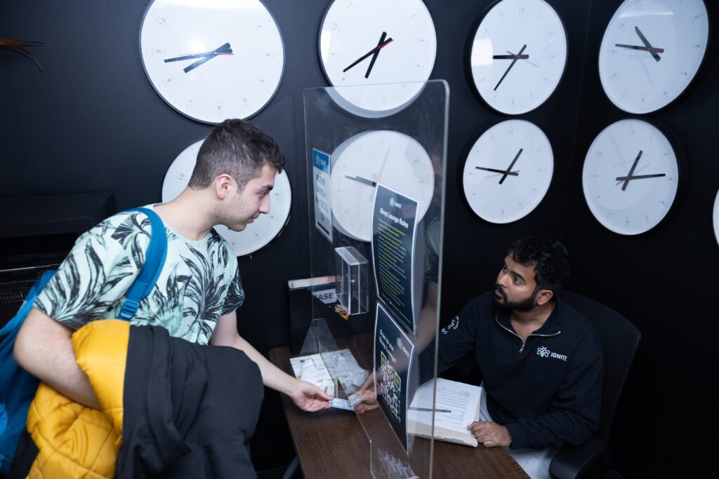 A wellbeing assistant helping a post-secondary student in the sleep lounge at the North campus.