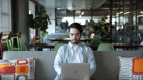 a man closing laptop while people behid him appear shaking their hand in celebration. Text reading "Task complete"