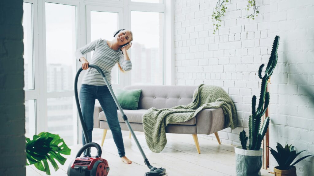 a person vacumming their house while listening to music