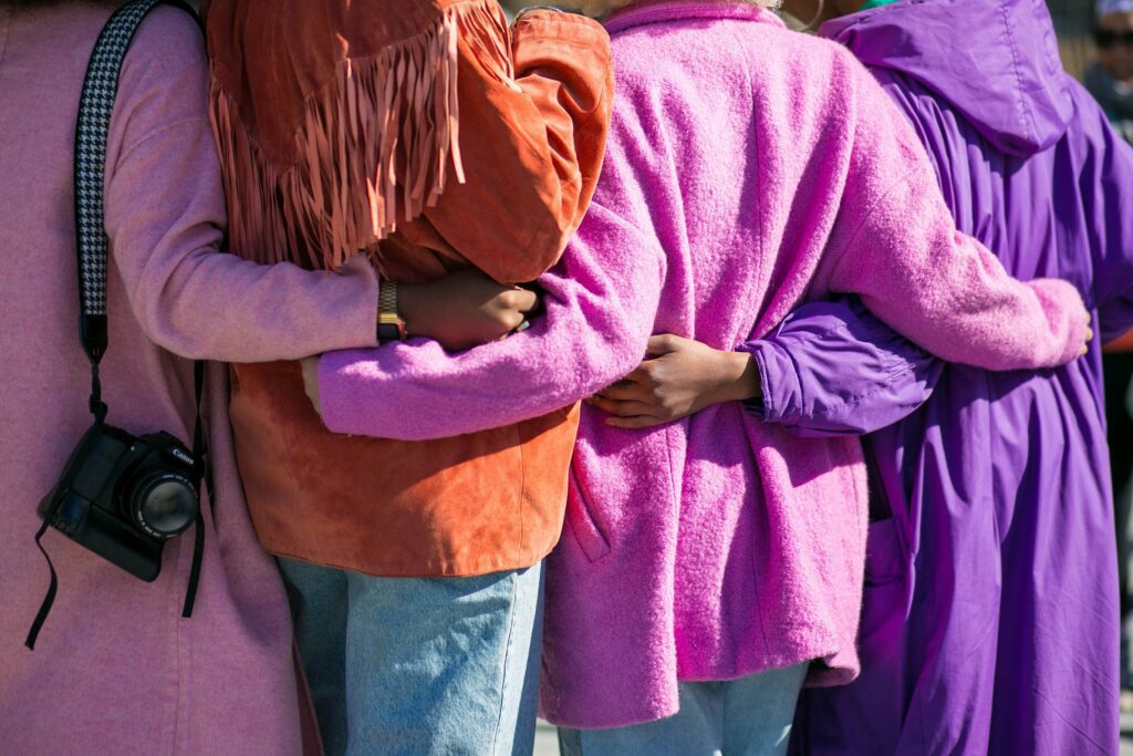 Women in vibrant cardigans hugging