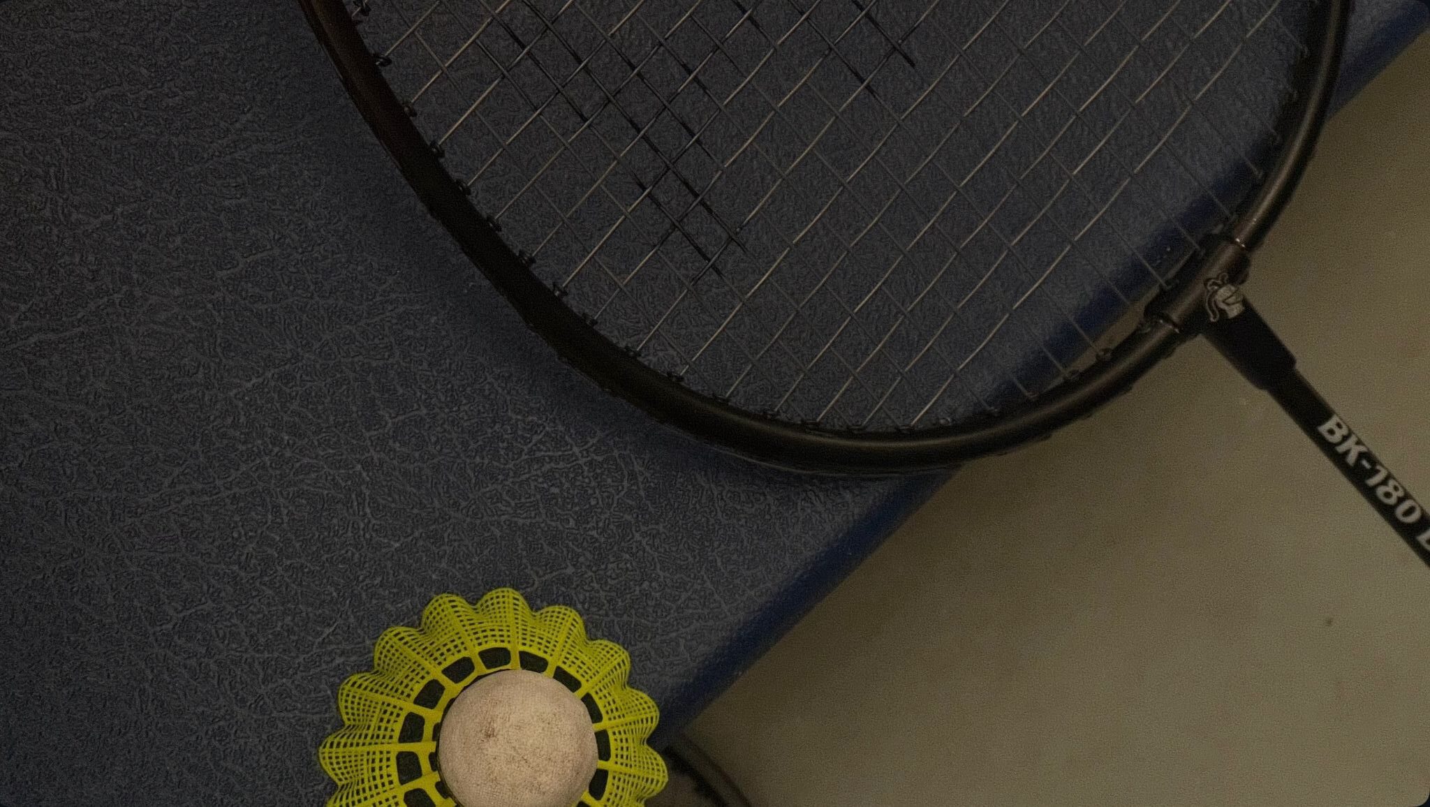 zoomed in photo of a badminton raquet and shuttle cock