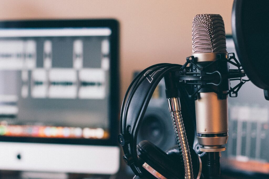 A deask with a microphone, monitor and a headset
