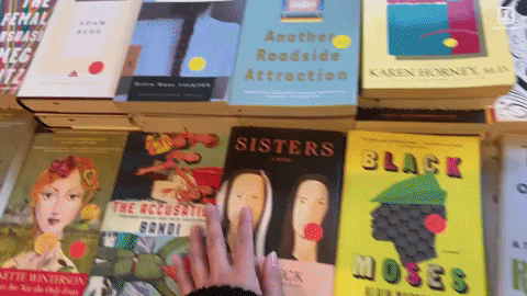 a hand gliding through various books
