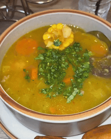 A spoon stirring corn soup. 